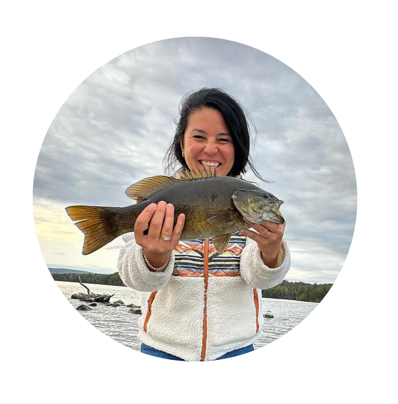 Pretty young lady angler holding a nice smallmouth bass for a picture before releasing it.